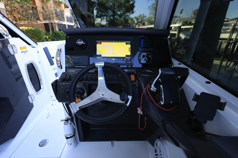  Yacht Photos Pics 2023 Blackfin 252 DC boat cockpit with steering wheel and navigation display.