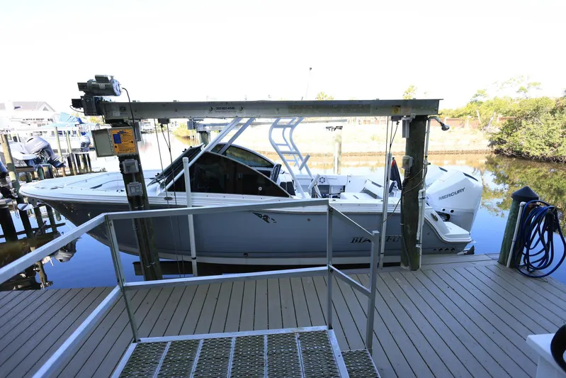  Yacht Photos Pics 2023 Blackfin 252 DC boat docked on a lift at a marina.