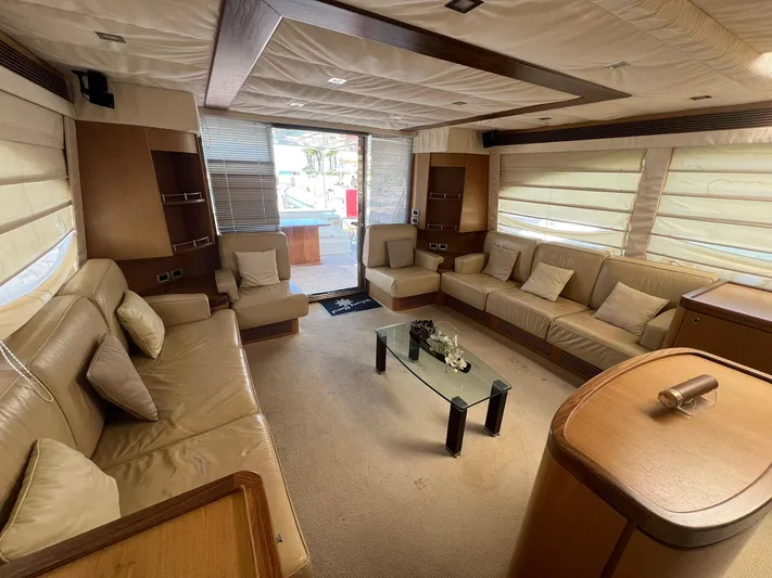 Amia Yacht Photos Pics Luxurious interior of 2006 Ferretti Yachts 731 with beige leather seating and glass coffee table.