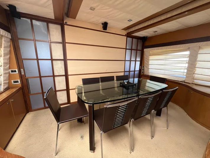 Amia Yacht Photos Pics Dining area in 2006 Ferretti Yachts 731 with glass table and modern chairs.
