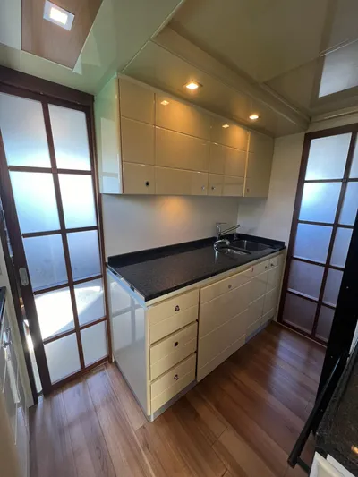 Amia Yacht Photos Pics 2006 Ferretti Yachts 731 kitchen with modern cabinetry and wood flooring.