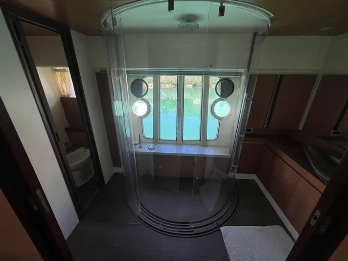 Amia Yacht Photos Pics Luxurious bathroom on 2006 Ferretti Yachts 731 with circular shower and porthole windows.