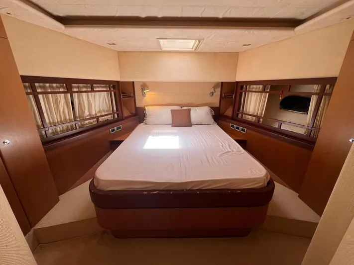 Amia Yacht Photos Pics Luxurious bedroom in a 2006 Ferretti Yachts 731 with a double bed and elegant wood finishes.