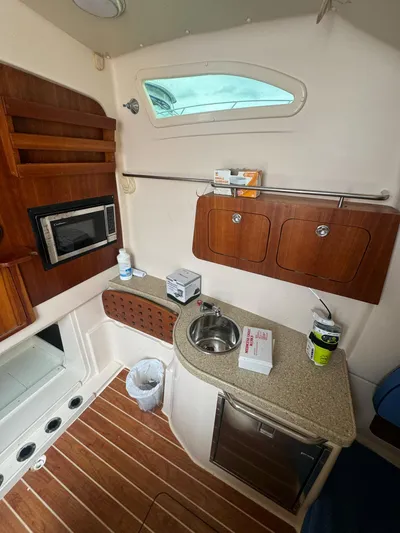  Yacht Photos Pics 2014 Grady-White Canyon 376 cabin interior with kitchenette, sink, and wooden cabinetry.