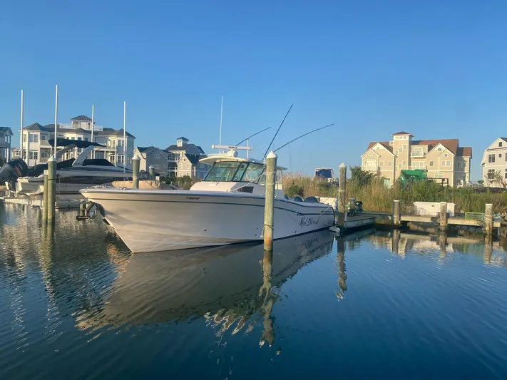  Yacht Photos Pics 2014 Grady-White Canyon 376 boat docked in a marina with waterfront homes.