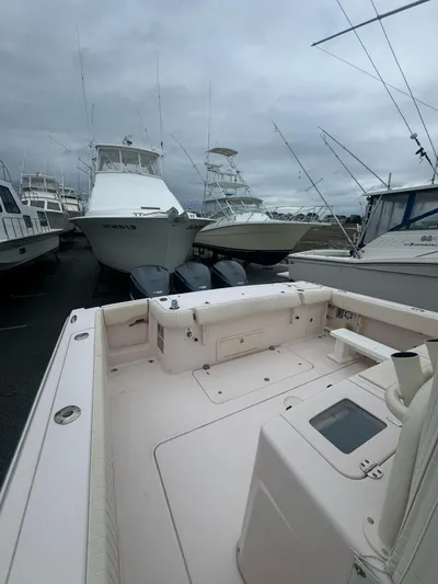  Yacht Photos Pics 2014 Grady-White Canyon 376 boat docked with other vessels under cloudy skies.
