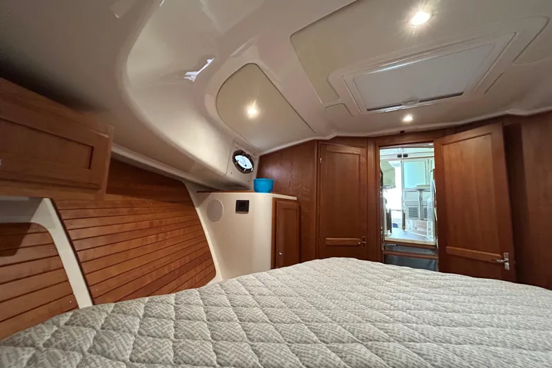 Esc Key Yacht Photos Pics 2023 Back Cove 39O cabin interior with wood paneling and cozy bedding.