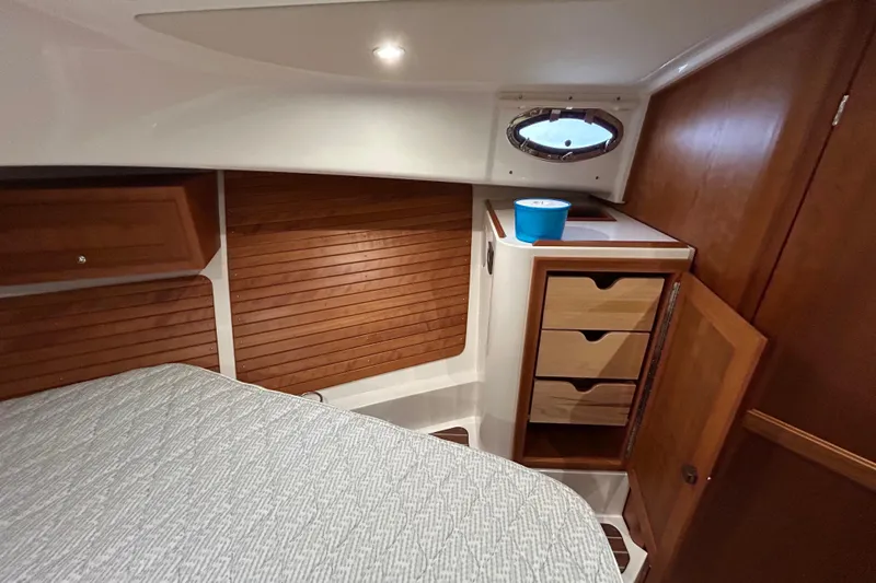 Esc Key Yacht Photos Pics 2023 Back Cove 39O cabin interior with wood paneling and storage drawers.
