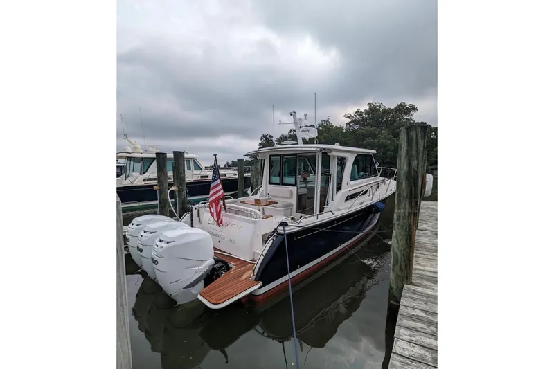 Esc Key Yacht Photos Pics 2023 Back Cove 39O boat docked with triple outboard engines and American flag.