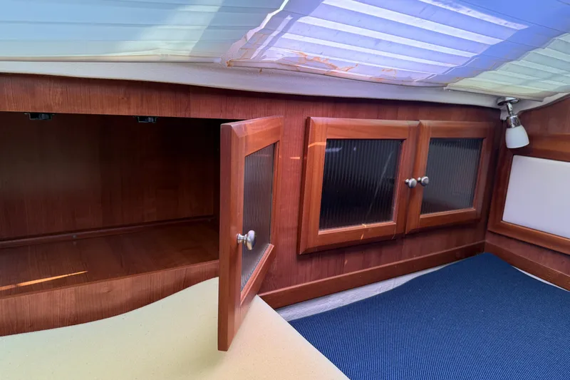 Sirenia Yacht Photos Pics Interior of 2014 Gemini Legacy 35 sailboat with wooden cabinets and blue mat.