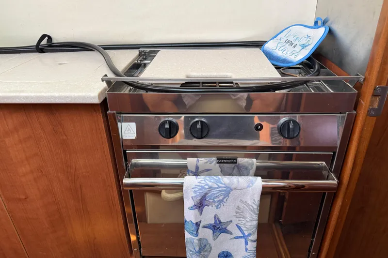 Sirenia Yacht Photos Pics Stainless steel stove in 2014 Gemini Legacy 35 boat kitchen with nautical-themed towel.