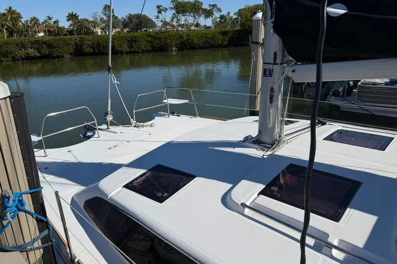 Sirenia Yacht Photos Pics 2014 Gemini Legacy 35 catamaran docked by a serene waterway.