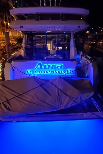 Aura Yacht Photos Pics Prestige 520 yacht, 2018 model, named "Aura," docked in Fort Lauderdale, illuminated at night.
