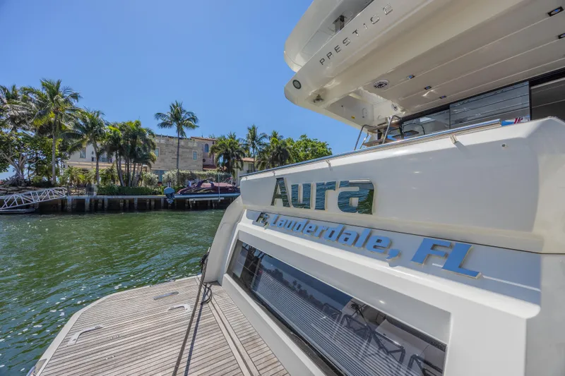 Aura Yacht Photos Pics 2018 Prestige 520 yacht docked in Fort Lauderdale, FL, with palm trees in the background.