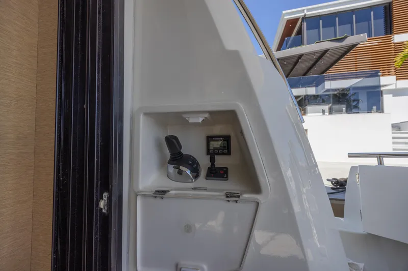 Aura Yacht Photos Pics Control panel on a 2018 Prestige 520 yacht, with modern architecture in the background.