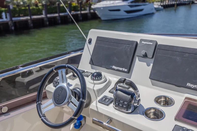 Aura Yacht Photos Pics Helm of 2018 Prestige 520 yacht with Raymarine navigation system, docked by the water.