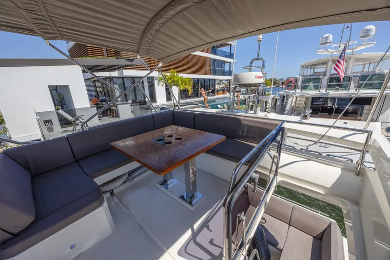 Aura Yacht Photos Pics Prestige 520 yacht 2018 model, featuring a spacious outdoor seating area with a wooden table.