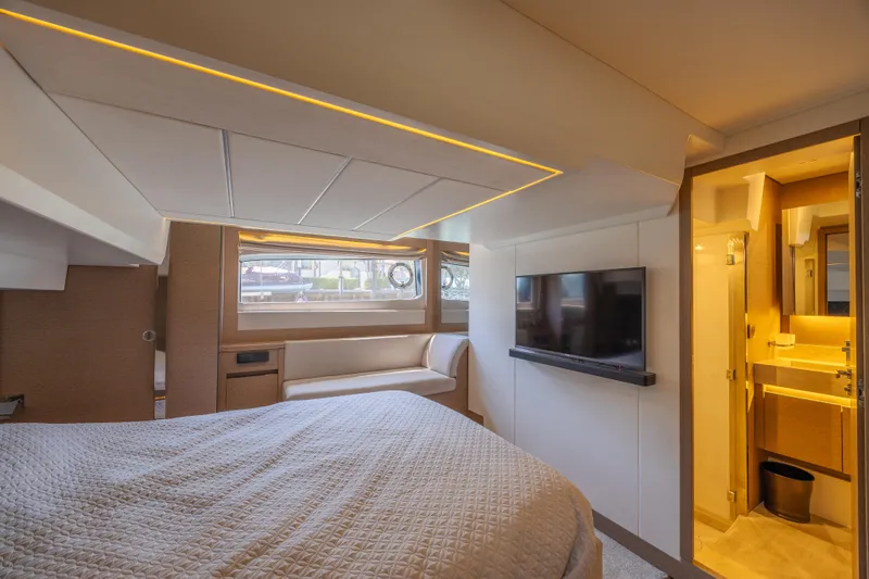 Aura Yacht Photos Pics Luxurious cabin interior of 2018 Prestige 520 yacht with bed, TV, and ensuite bathroom.