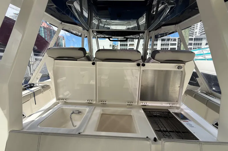  Yacht Photos Pics 2022 Pursuit S 358 Sport boat interior with seating and storage compartments.