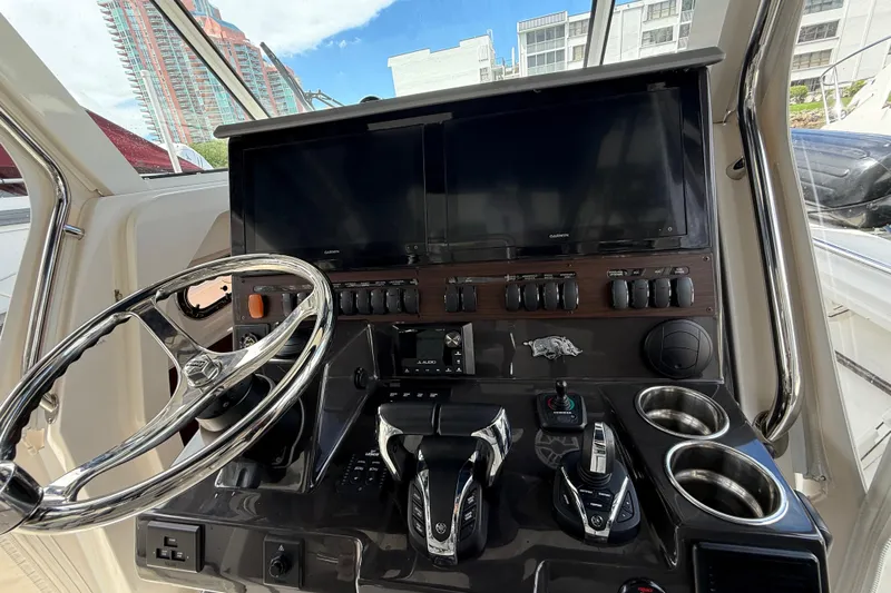  Yacht Photos Pics 2022 Pursuit S 358 Sport boat dashboard with steering wheel and control panel.