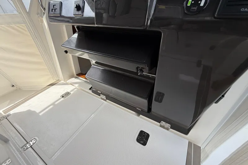  Yacht Photos Pics 2022 Pursuit S 358 Sport boat interior with storage compartments and control panel.