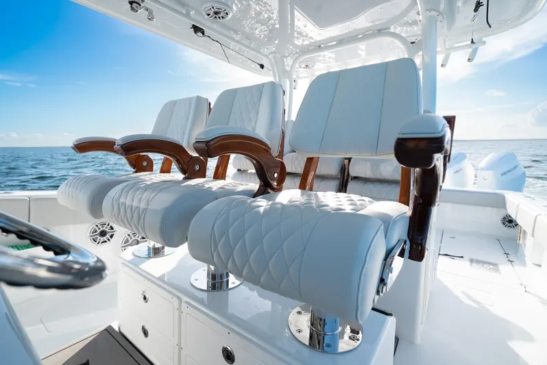  Yacht Photos Pics Luxurious seating on a 2023 Freeman 43 boat, featuring elegant white upholstery and wooden armrests.