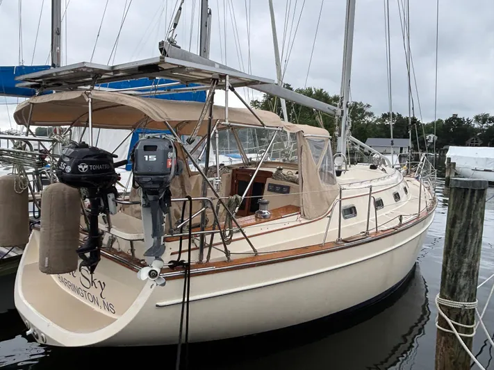 Blue Sky Yacht Photos Pics 2001 Island Packet 380 sailboat docked, featuring dual outboard motors and beige canopy.