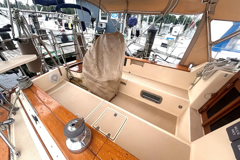 Blue Sky Yacht Photos Pics 2001 Island Packet 380 sailboat cockpit with wooden trim and covered helm, docked at marina.