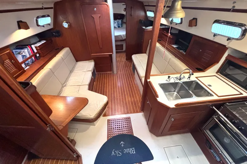 Blue Sky Yacht Photos Pics Interior of 2001 Island Packet 380 sailboat with wood finish and cozy seating area.