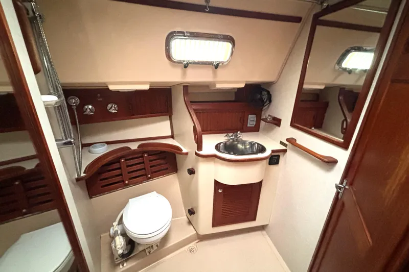 Blue Sky Yacht Photos Pics 2001 Island Packet 380 yacht bathroom with sink, toilet, and wooden accents.