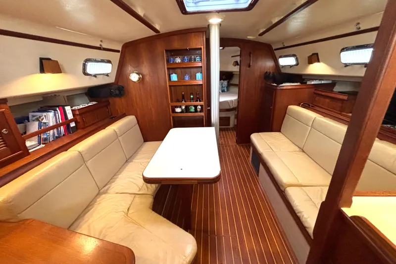 Blue Sky Yacht Photos Pics Interior of 2001 Island Packet 380 sailboat with cozy seating and wooden finishes.