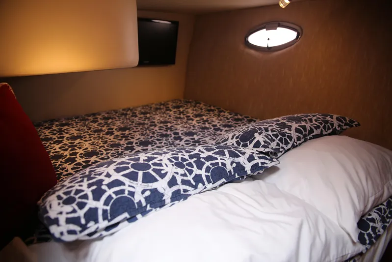  Yacht Photos Pics Cozy cabin interior of 2008 Silverton 38 Sport Bridge with patterned bedding and porthole window.