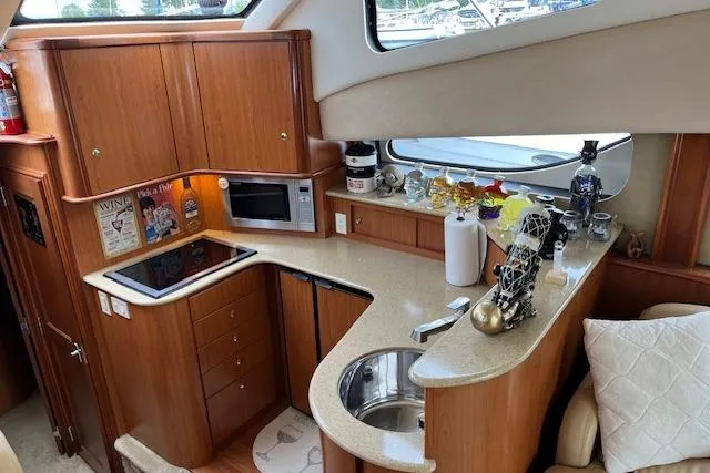  Yacht Photos Pics 2008 Silverton 38 Sport Bridge yacht interior with modern kitchen and wooden cabinetry.