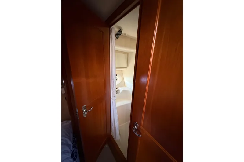  Yacht Photos Pics 2008 Silverton 38 Sport Bridge yacht interior with wooden door and bathroom view.