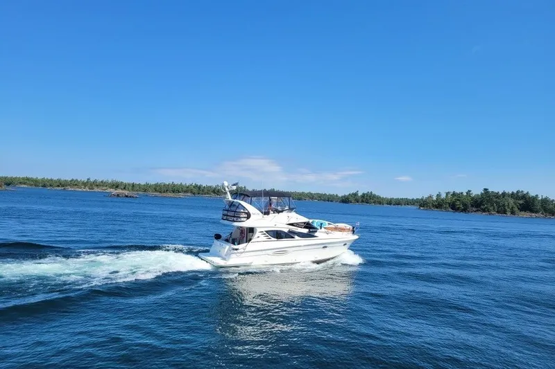  Yacht Photos Pics 2008 Silverton 38 Sport Bridge cruising on a clear blue lake under a sunny sky.