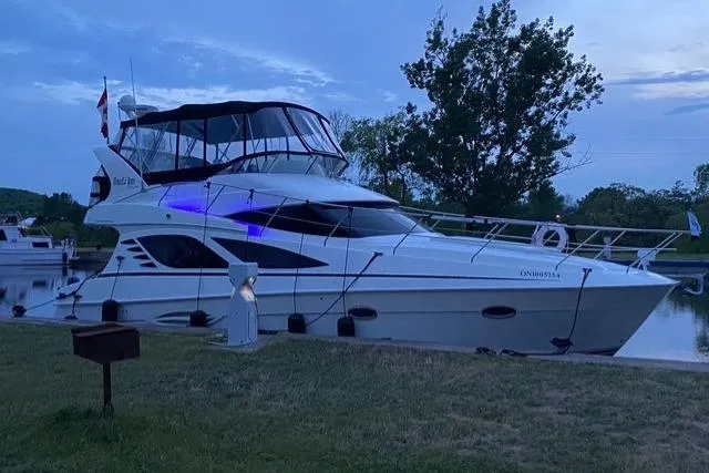  Yacht Photos Pics 2008 Silverton 38 Sport Bridge yacht docked at twilight, featuring sleek design and blue accent lighting.
