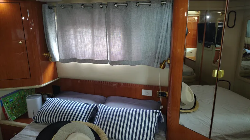 Spectre Yacht Photos Pics Cozy cabin interior of 2001 Sea Ray 420 Aft Cabin with striped pillows and hats.