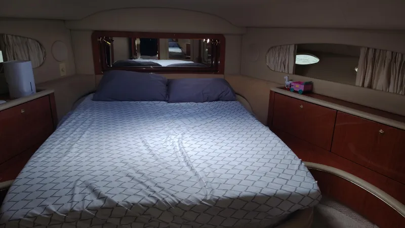 Spectre Yacht Photos Pics Luxurious bedroom in 2001 Sea Ray 420 Aft Cabin yacht with elegant wood cabinetry.
