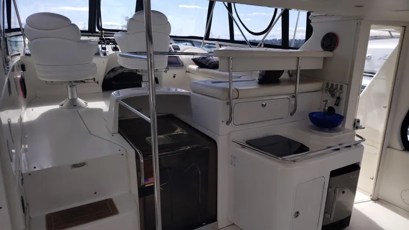 Spectre Yacht Photos Pics 2001 Sea Ray 420 Aft Cabin interior with helm, seating, and kitchenette.