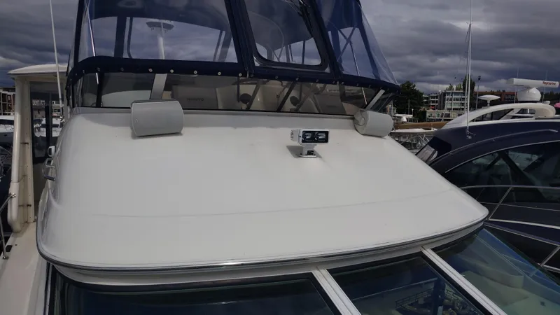 Spectre Yacht Photos Pics 2001 Sea Ray 420 Aft Cabin yacht with blue canopy, docked at marina.