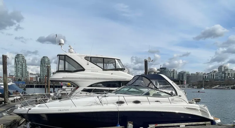  Yacht Photos Pics 2004 Sea Ray 360 Sundancer yacht docked in a marina with city skyline background.