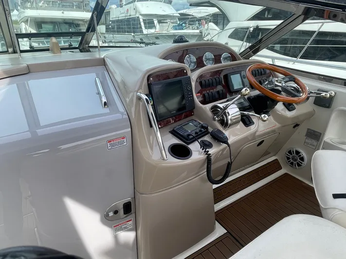  Yacht Photos Pics 2004 Sea Ray 360 Sundancer helm with wood accents and modern navigation equipment.