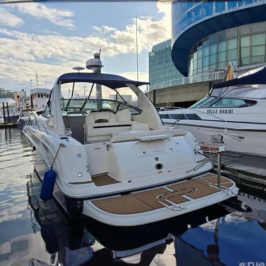  Yacht Photos Pics 2004 Sea Ray 360 Sundancer yacht docked at marina, modern buildings in background.