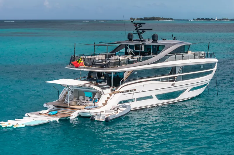 Gemini Yacht Photos Pics Luxurious 2023 Princess X95 yacht on turquoise ocean waters, featuring sleek design and spacious decks.