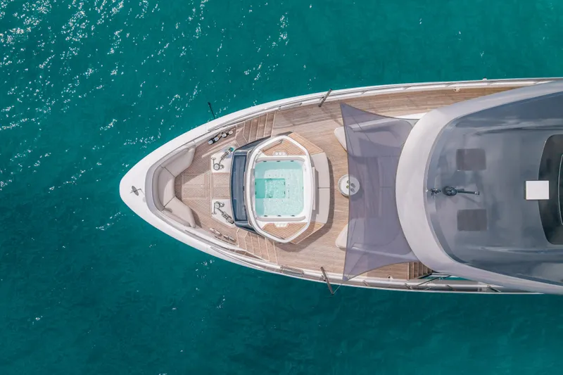 Gemini Yacht Photos Pics Aerial view of 2023 Princess X95 yacht with jacuzzi on turquoise water.