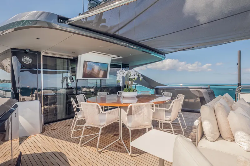 Gemini Yacht Photos Pics Luxurious 2023 Princess X95 yacht deck with elegant dining area and ocean view.