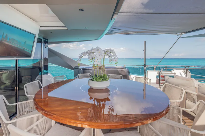 Gemini Yacht Photos Pics Luxurious 2023 Princess X95 yacht deck with elegant dining area and ocean view.