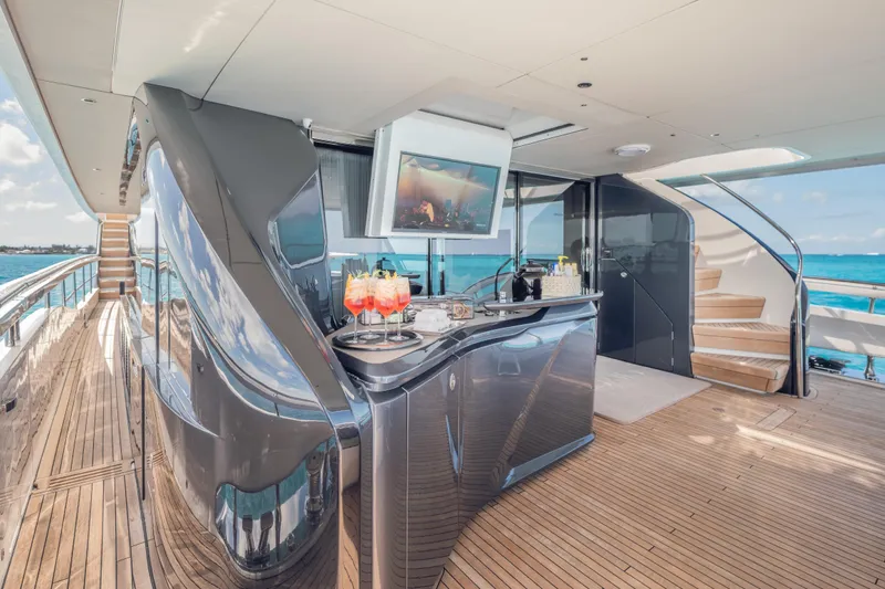Gemini Yacht Photos Pics Luxurious 2023 Princess X95 yacht deck with bar, TV, and ocean view.