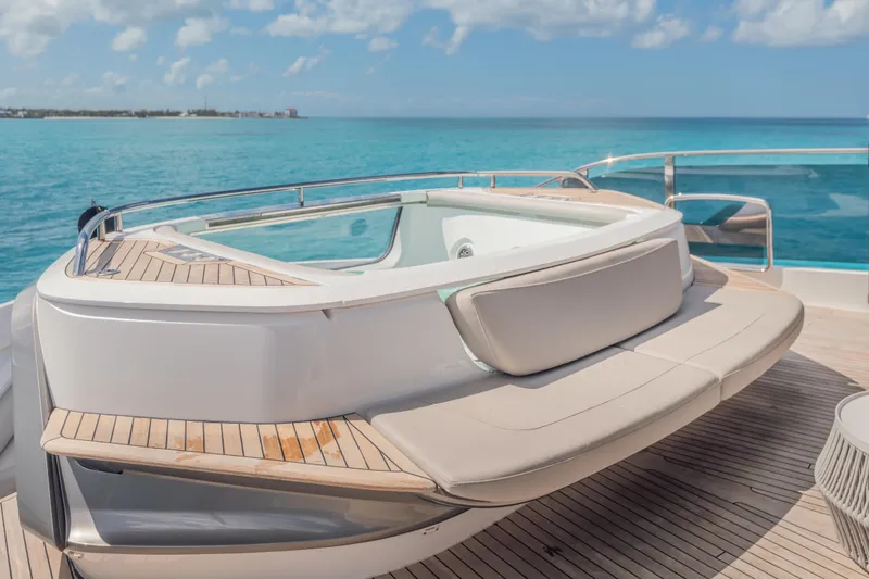 Gemini Yacht Photos Pics Luxurious 2023 Princess X95 yacht deck with jacuzzi, overlooking serene ocean waters.
