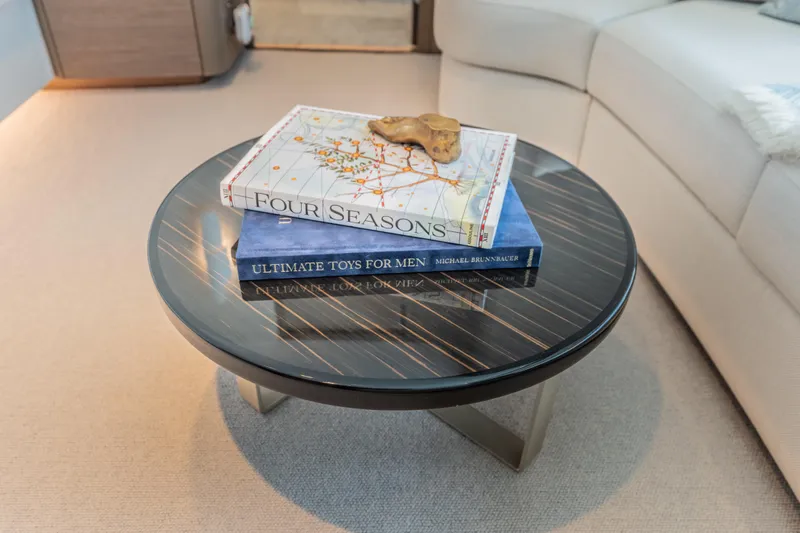 Gemini Yacht Photos Pics Luxurious Princess X95 yacht interior with elegant round table and decorative books, 2023 model.